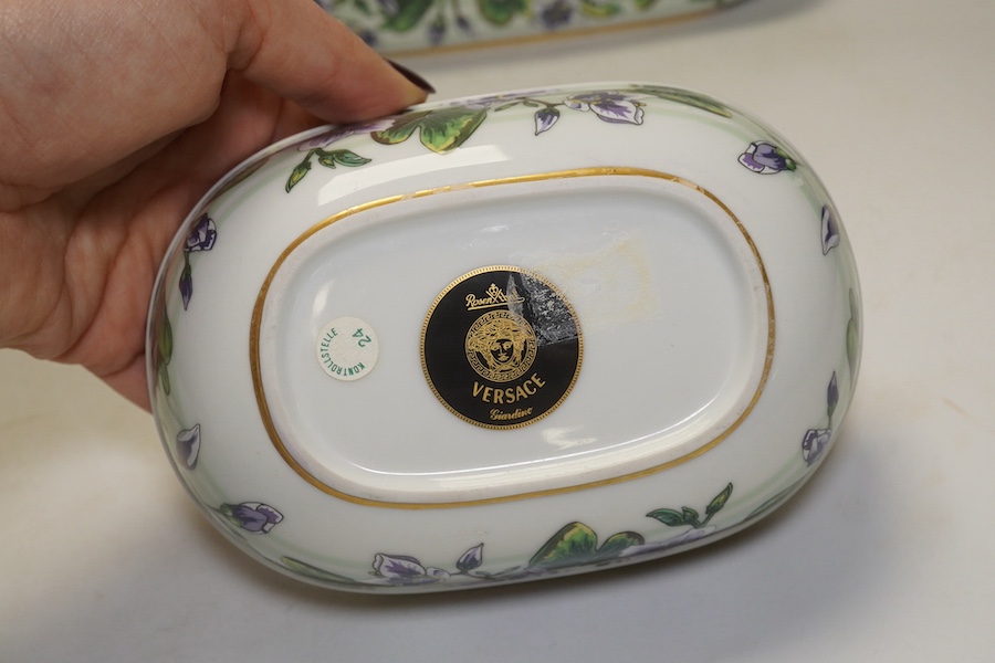 Six Rosenthal for Versace porcelain items; a boxed chocolate cup and saucer, four oblong serving dishes, longest 23cm, and a boxed miniature timepiece, 8.5cm high. Condition - good.